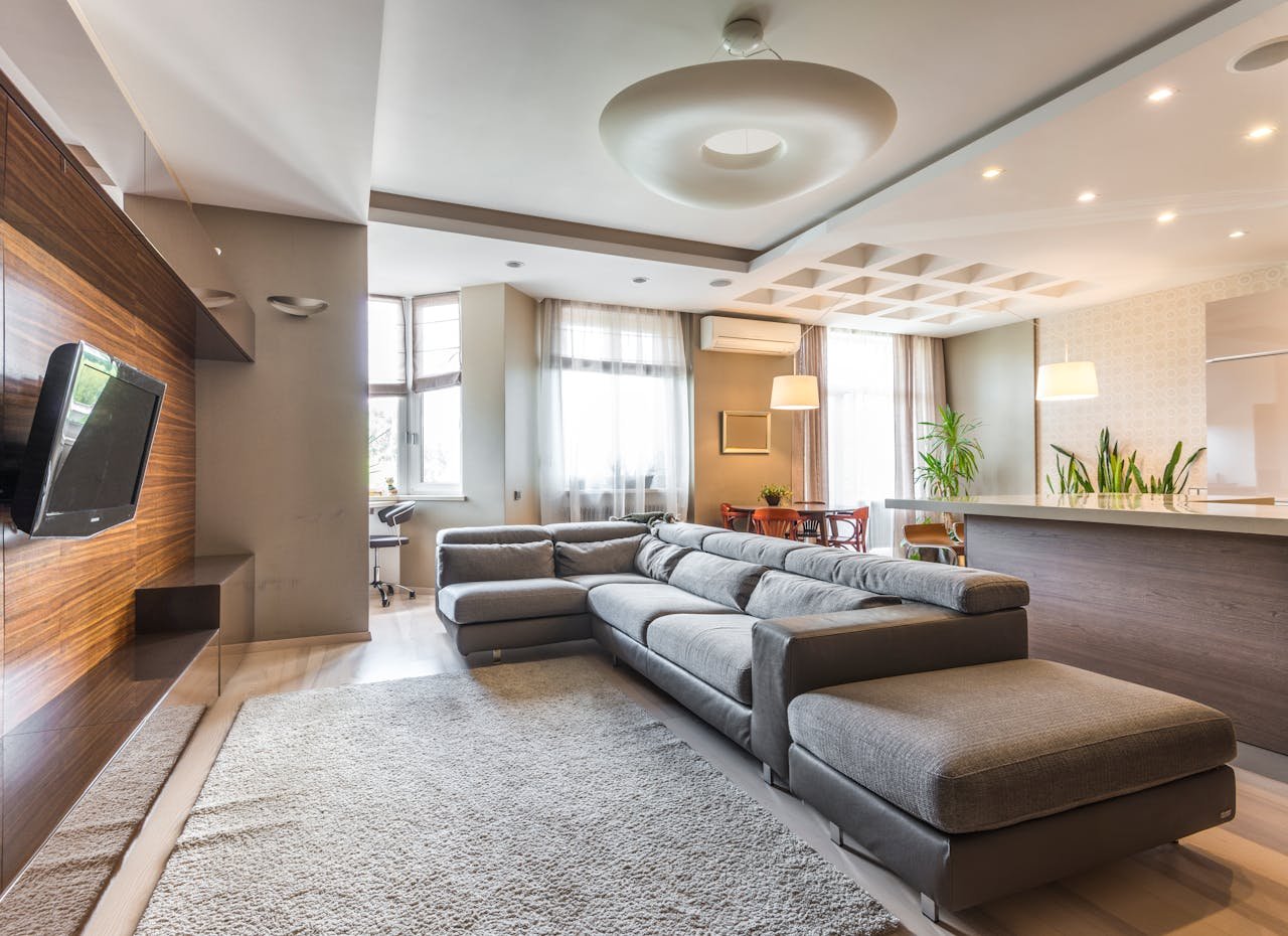 journey Spacious contemporary living room featuring a sleek grey sectional sofa and open kitchen design.