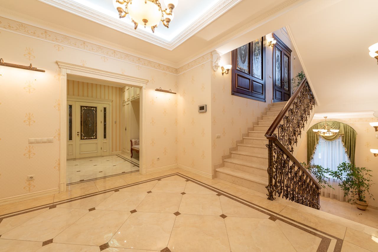 why-choose-us A spacious, well-lit interior featuring a grand staircase and elegant chandelier. Perfect for luxury interior design inspiration.